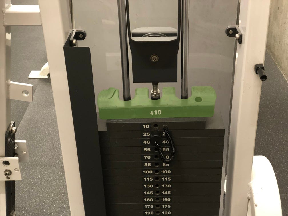The add-on weight in green, wider, with different ends and a +10 label